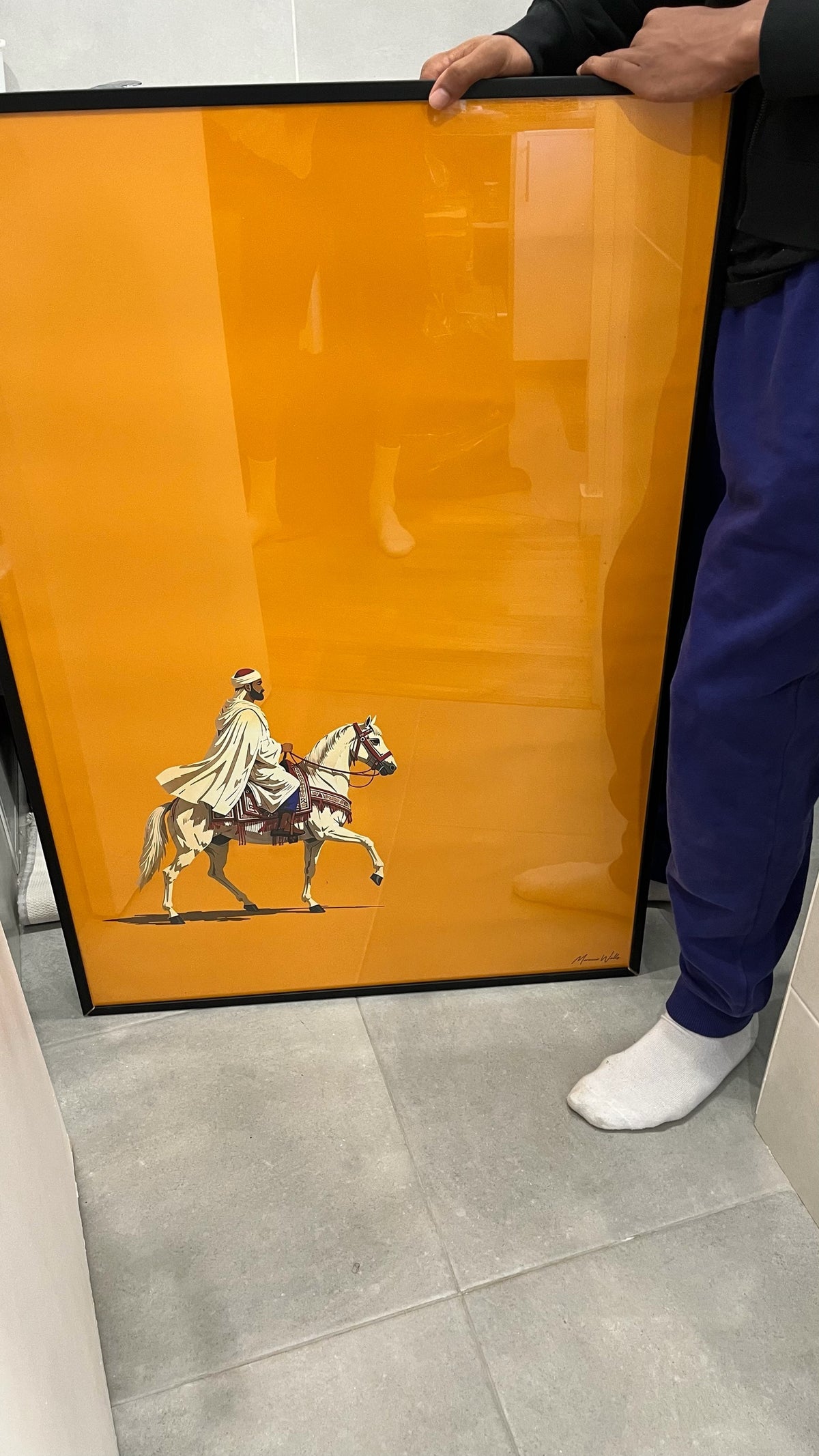 Affiche Morocco Walls orange au cavalier, cadre noir, tenue en main